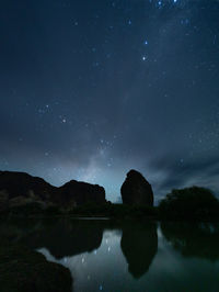 Low angle view of silhouette woman standing against sky at night