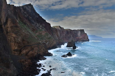 Scenic view of sea and rock formation against sky