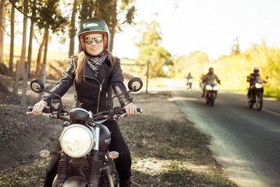 Beautiful woman sitting on motorcycle at roadside