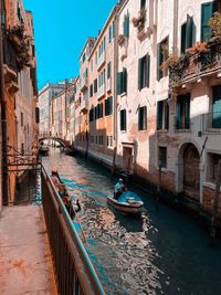 Boats in canal amidst buildings in city