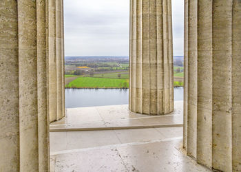 View of colonnade against sky seen through window