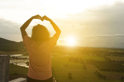 Silhouette of woman against sky during sunset