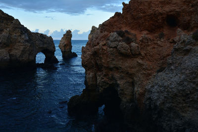 Rocks on sea shore against sky