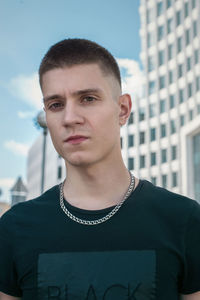 Portrait of young man standing against built structure