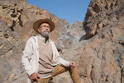 Portrait of young woman standing against rock formations