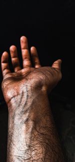 Close-up of human hand against black background