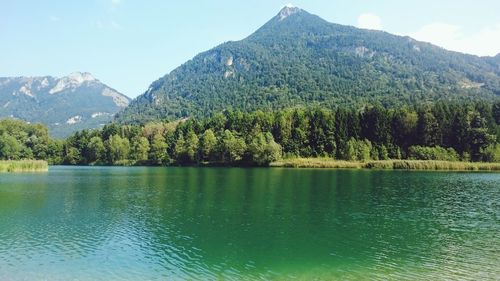 Scenic view of lake by mountains against clear sky