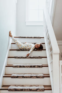Low angle view of woman lying down on staircase at home