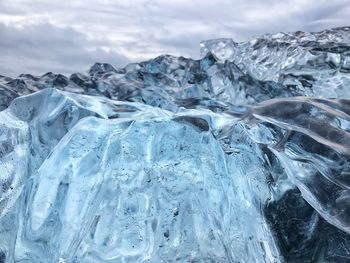 Close-up of frozen mountain against sky