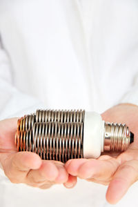 Midsection of man holding light bulb