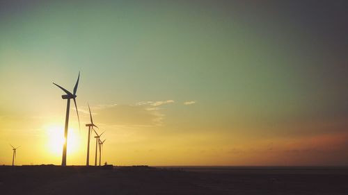 Silhouette of wind turbines at sunset