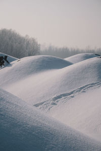 Snow covered landscape against sky