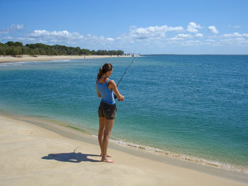 Woman fishing on inskip point, rainbow beach, australia.