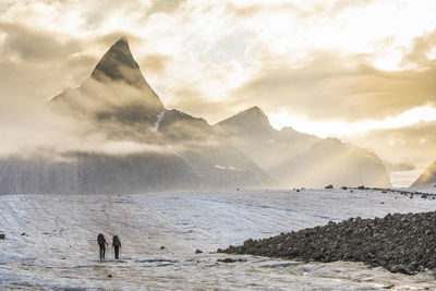 Rear view of silhouetted climbers en route to mt. loki.