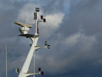 Low angle view of radar against cloudy sky