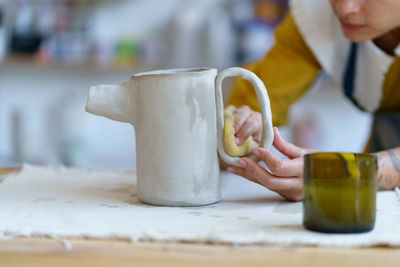 Young sculptor girl create ceramic tableware in studio. woman pottery artist work with wet clay
