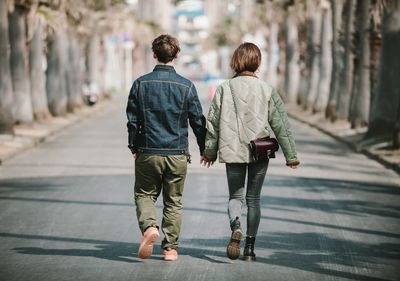 Rear view of people walking on footpath