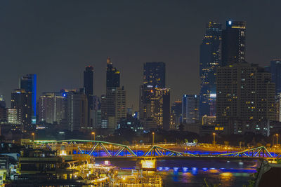 Illuminated buildings against sky at night