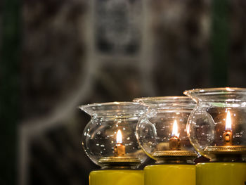 Close-up of illuminated diya in jars