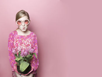 Mod blonde tween fair skin with pink tulips, pink dress, pink backdrop