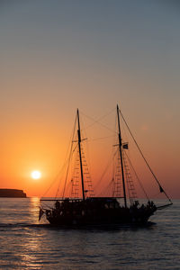 Sailboat in sea against sky during sunset