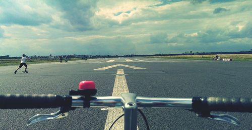 Man riding bicycle on road against sky