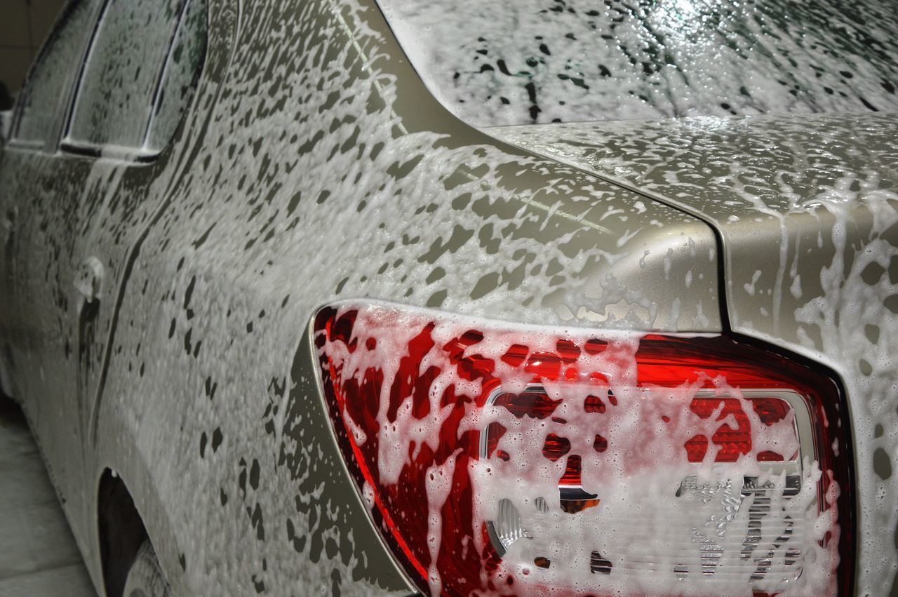 CLOSE-UP OF WET RED CAR WINDOW