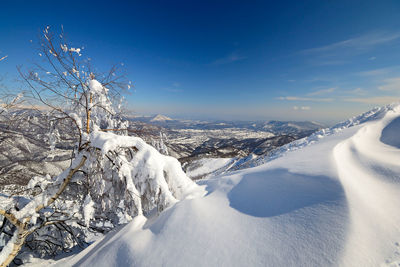 Snow covered landscape against sky