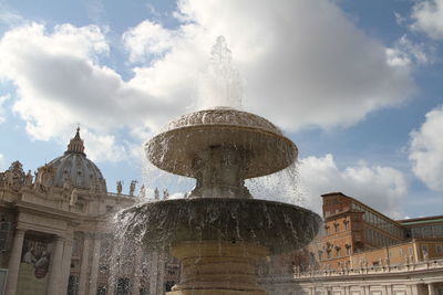 Fountain at st peter basilica against sky