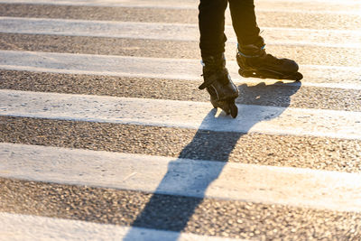 Low section of man walking on road