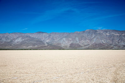 Scenic view of desert against blue sky