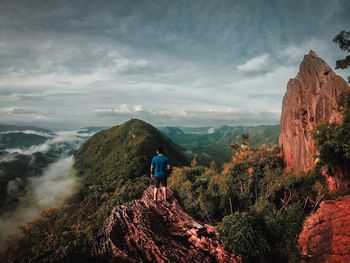 Rear view of man on mountain against sky