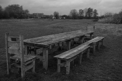 Weathered dining table against cloudy sky