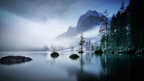 Panoramic view of lake by trees against sky