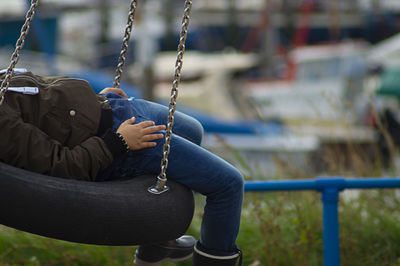 Man sitting on swing at playground