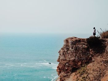 People looking at sea against sky