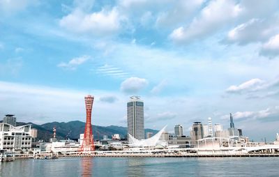 Buildings by sea against sky in city