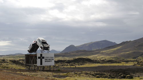 Information sign on landscape against sky