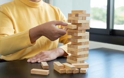 Midsection of boy playing with toy blocks