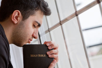 Close-up portrait of young man holding book