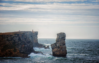 Rocks on sea shore against sky