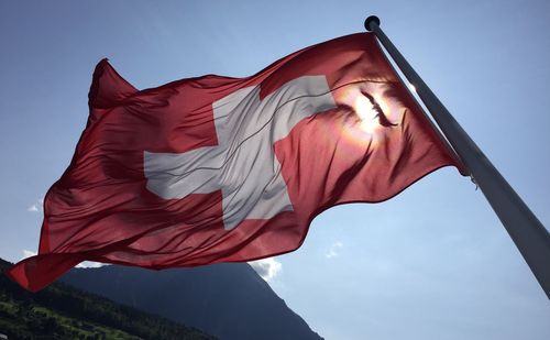 Low angle view of swiss flag against clear sky 