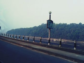 Road leading towards mountains against clear sky