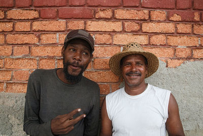 Portrait of men standing by wall outdoors