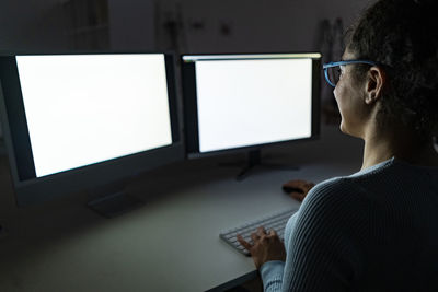 Freelancer working on two monitors at home office