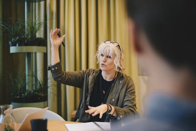 Confident businesswoman explaining strategy while sitting at conference table