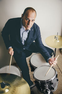 Portrait of confident drummer playing drums