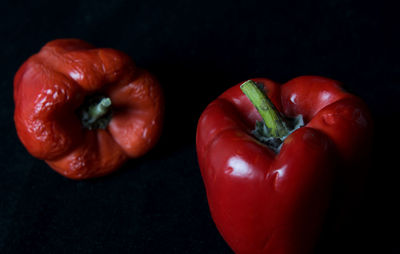 Close-up of bell peppers on table against black background