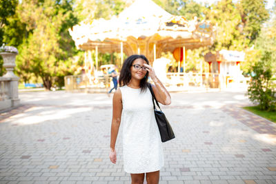 Portrait of young woman standing in city
