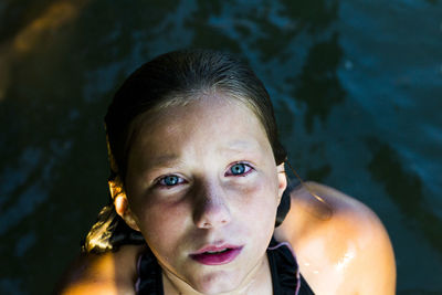 Close-up portrait of shirtless boy swimming in water